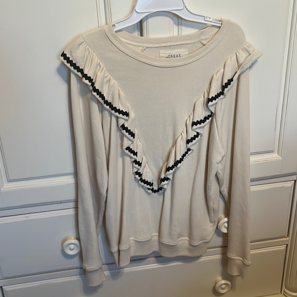 cream sweater with V-shaped ruffles